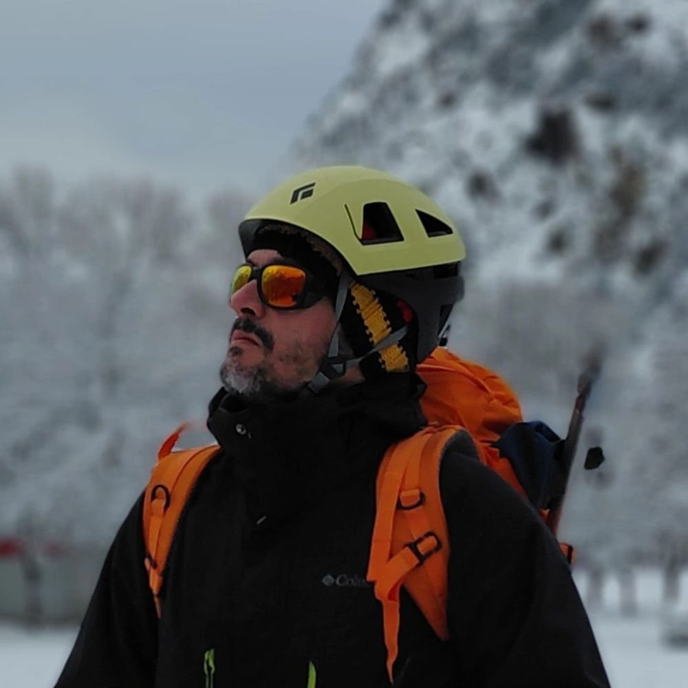 Armando Valdés Aumente con casco y gafas de montaña en un paisaje nevado
